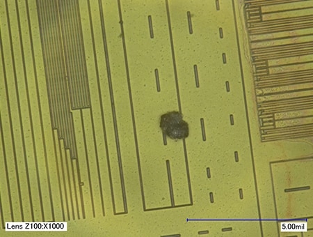 Partícula extraña mezclada en un chip de CI (1000x)